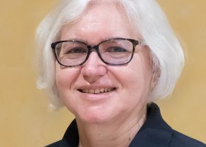 Frau mit Brille und in dunkelblauem Malteser Polo