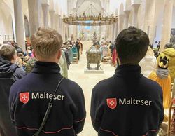 Zwei Malteser stehen im Hildesheimer Dom beim Sternsingerdankgottesdienst