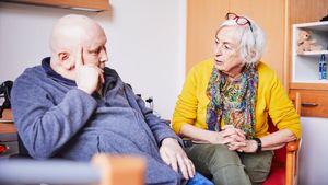 Ein Mann und eine Frau sitzen neben einadner und unterhalten sich