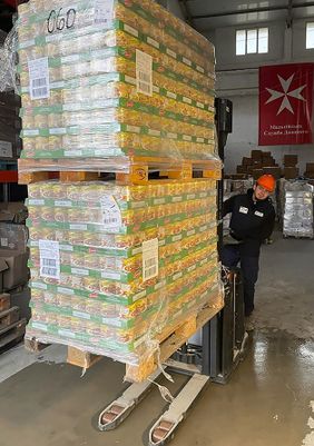 Dieses Bild zeigt einen ukrainischen Helfer der Malteser im Logistikzentrum Lviv beim Entladen der Hilfsgüter.