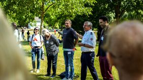Eine Personengruppe steht in einem Park.