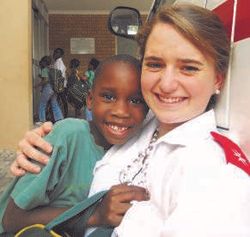 Freiwillige Iona Hughan mit einem Kind vor dem Kinderheim