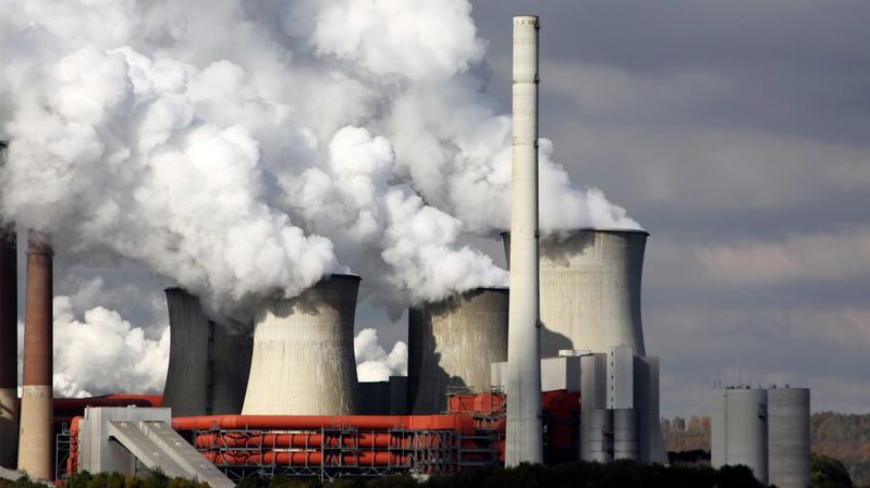 Schlote eines Kraftwerks aus denen weiße Wasserdampfwolken aufsteigen