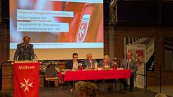 Der Diözesanvorstand sitzt auf dem Podium, während Dr. van Lengerich den Bericht vorträgt