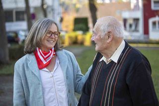 Helferin spricht mit älterem Herr