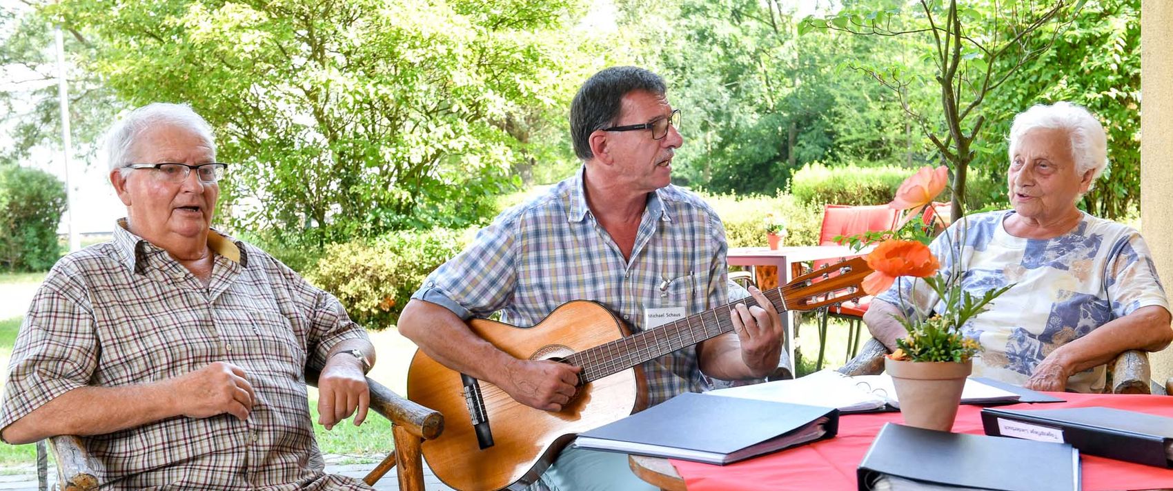 Begleiter des sozialen Dienst spielt für die Bewohner Gitarre und alle singen zusammen