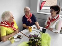 Drei Frauen am Tisch unterhalten sich