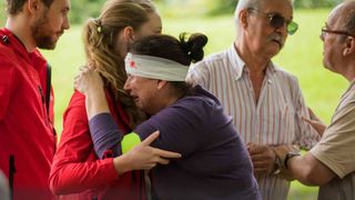 Bei einer Katastrophenschutzübung weint eine Verletzte und wird getröstet.