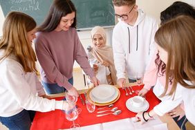 Schüler üben das Tischdecken