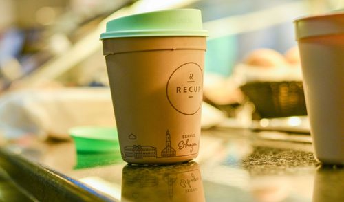 Mehrweg-Kaffeebecher auf einer Theke im Kaffeebereich.