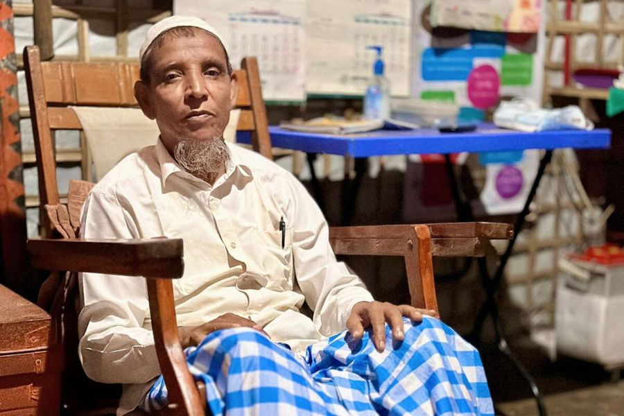 Mohammad Akter sits in his wooden easy chair.