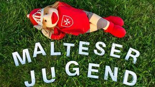 Schriftzug Malteser Jugend mit Puppe von Ritter Malte