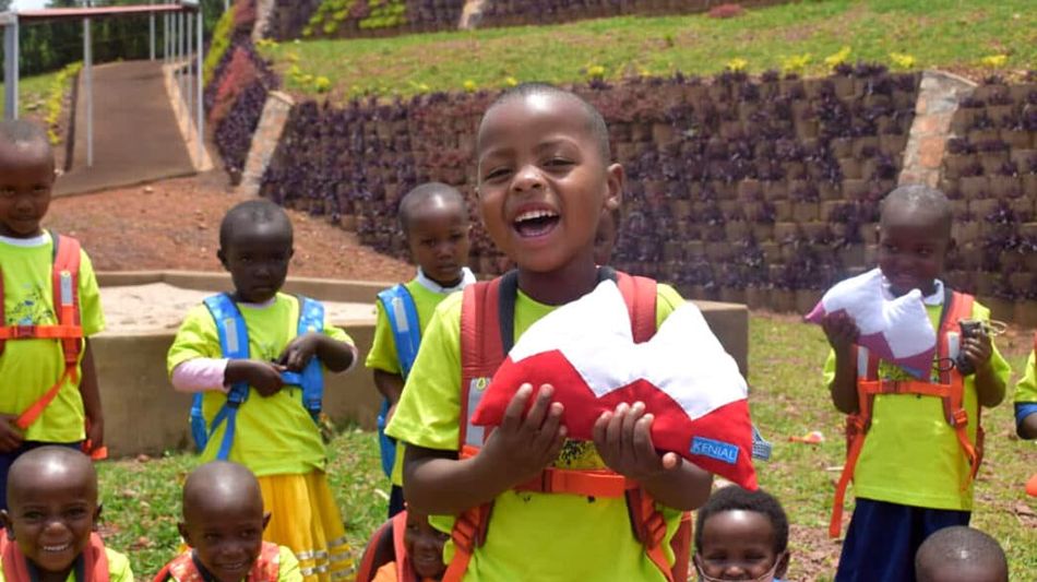 Zu sehen ist eine afrikanische Schulklasse mit genähten Produkten.