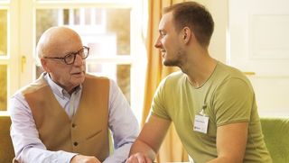 Ein älterer und ein jüngerer Mann im Gespräch.