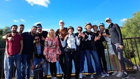 Menschen haben sich für eine Foto aufgestellt. Sie haben Fahrradhelme auf dem Kopf.