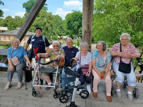 Die Gruppe der Malteser Lindheimer Seniorinnen machen auf ihrem Tagesausflug Rast auf einer Bank im Kurpark in Bad Orb. Foto: Malteser