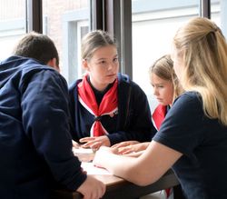 Carolina tauscht sich im Gruppenraum der Malteser mit anderen Kindern und Jugendlichen aus