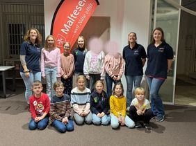 Gruppe von Kindern und Jugendlichen vor Malteser Schild