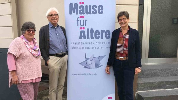 Drei Senioren werben für ein Straßenplakat mit dem Titel: Mäuse für Ältere.