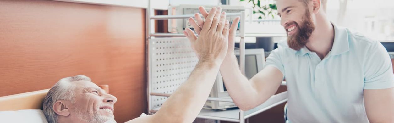 Junger Mann gibt Pflegebedürftigem ein High Five