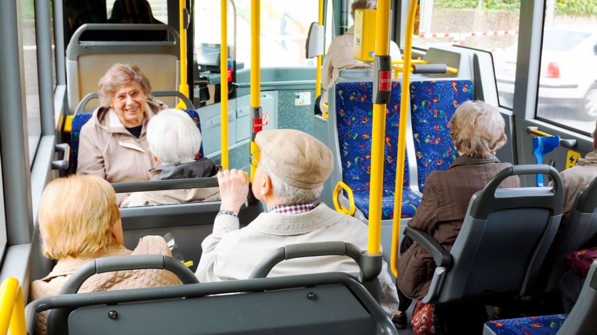 Eine Gruppe älterer Menschen in einem öffentlichen Bus.