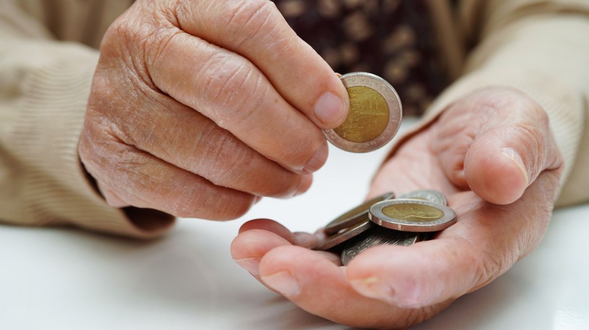 Eine Hand, in der mehrere Zwei-Euro-Geldstücke liegen.