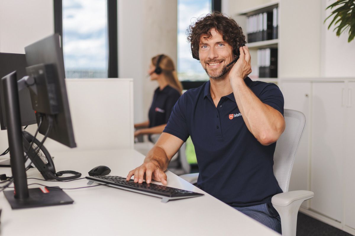 Malteser Mitarbeiter in der Hausnotrufzentrale nimmt einen Anruf an.