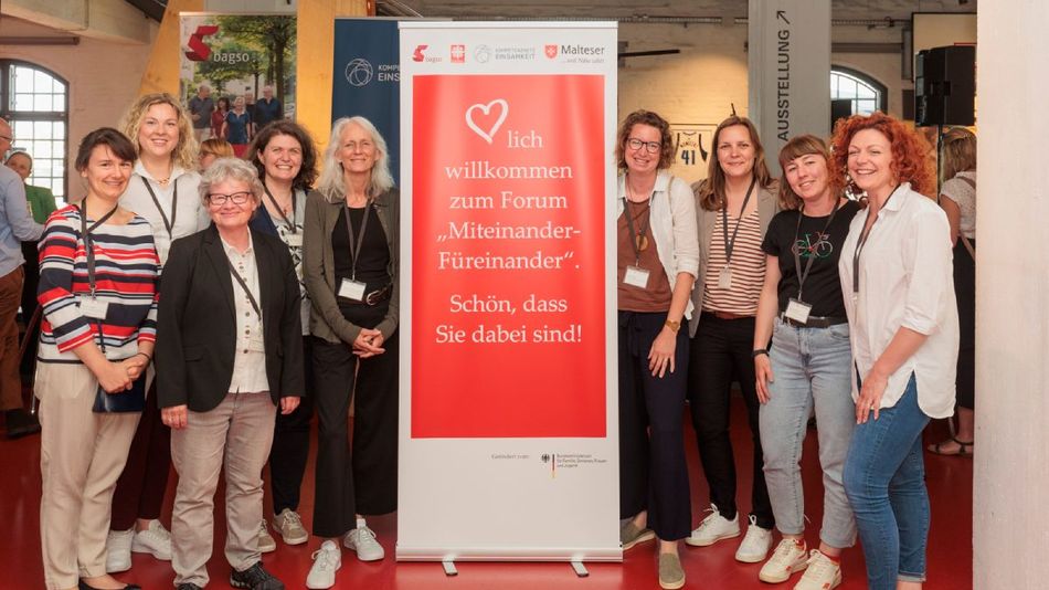 Eine Gruppe Frauen vor einem Banner.