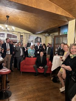 Axel Lemmen sitzt inmitten seiner Gäste auf einem roten Sofa 