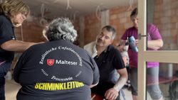 Drei Mitglieder der schminken gemeinsam einen Verletztendarsteller