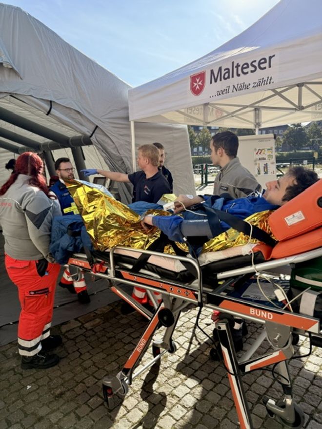 In dieser simulierten Situation wird ein Verletzter auf einer Trage ins Behandlungszelt gebracht. 