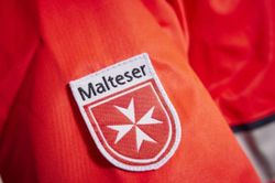 Der Ärmel einer Einsatzjacke mit Malteserlogo