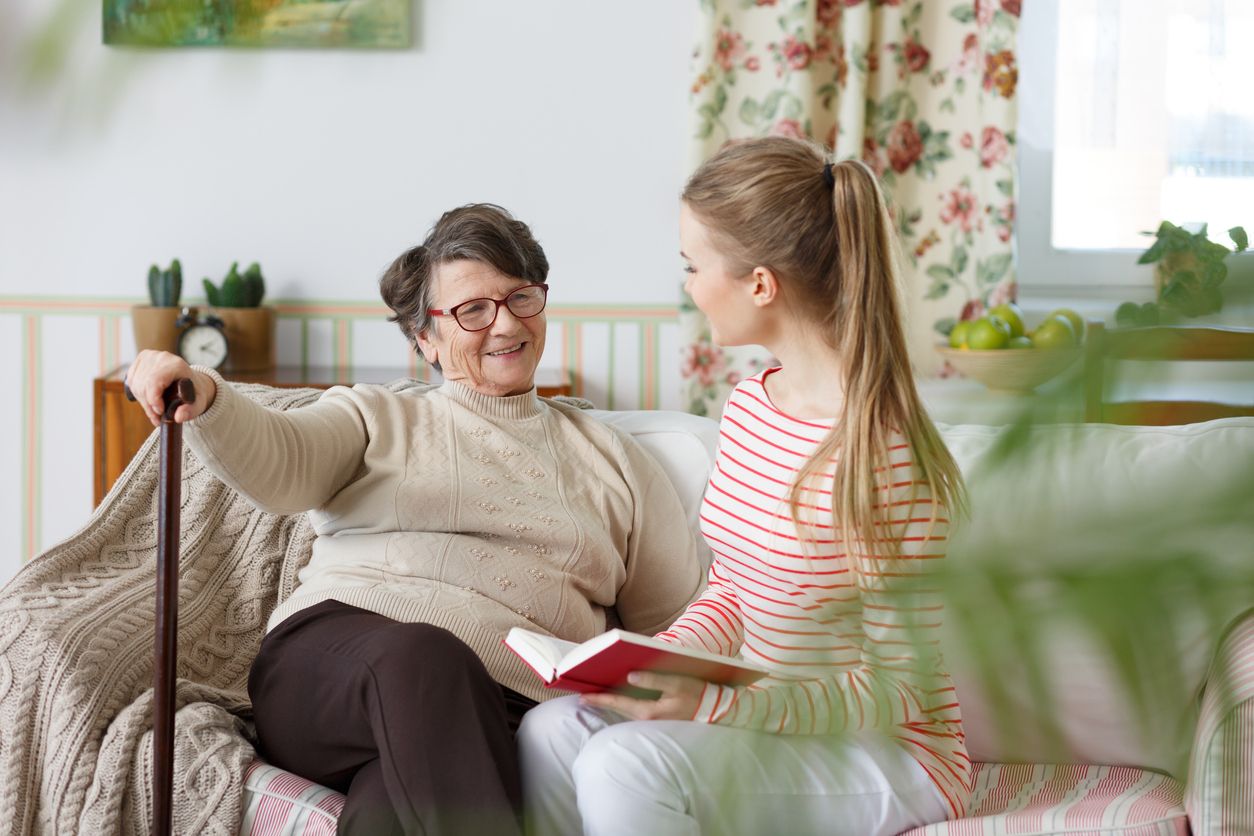 Junge Frau liest Senioren vor