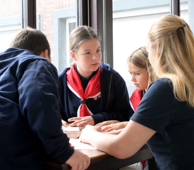 Carolina tauscht sich im Gruppenraum der Malteser mit anderen Kindern und Jugendlichen aus