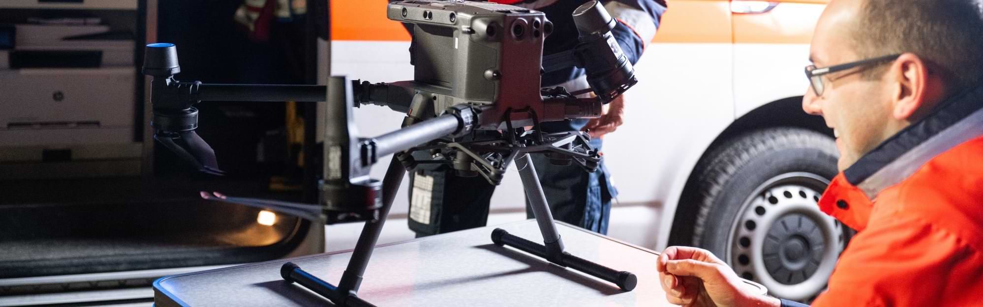 Zwei Männer von der Malteser Drohnenstaffel bereiten eine Drohne für einen Einsatz vor.