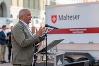 Ein Mann steht am Mikrofon und hält eine Rede