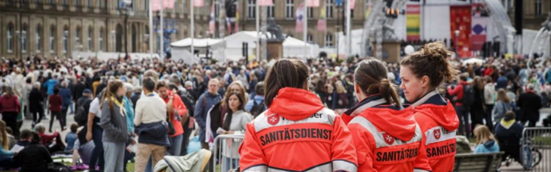 Drei Rettungssanitäterinnen stehen am Rande eines Großevents.