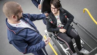 Rollstuhlfahrerin im Gespräch mit einem Fahrer der Malteser