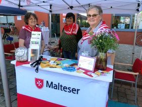 Drei Frauen an einem Info-Stand der Malteser.