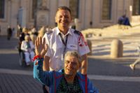 Ein Mann begleitet einen Menschen mit Behinderung im Rollstuhl. Foto: Malteser