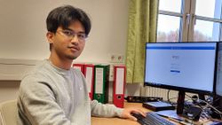 Ein junger Mann sitzt an einem Computer.