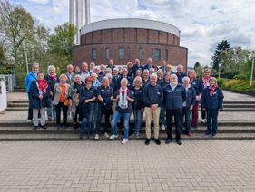 Gruppenfoto der Ehrenamtlichen auf der Treppe mit der Kolumbariumskirche im Hintergrund