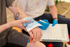 Eine Patientin legt ein Kühlpad auf eine Wunde