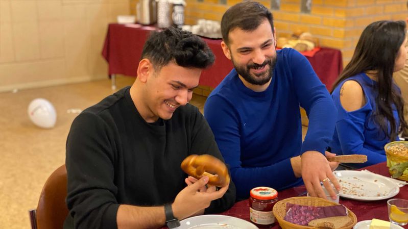 Lächelnde Menschen an einem gedeckten Tisch