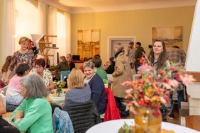 Menschen sitzen gemütlich zusammen und reden miteinander.