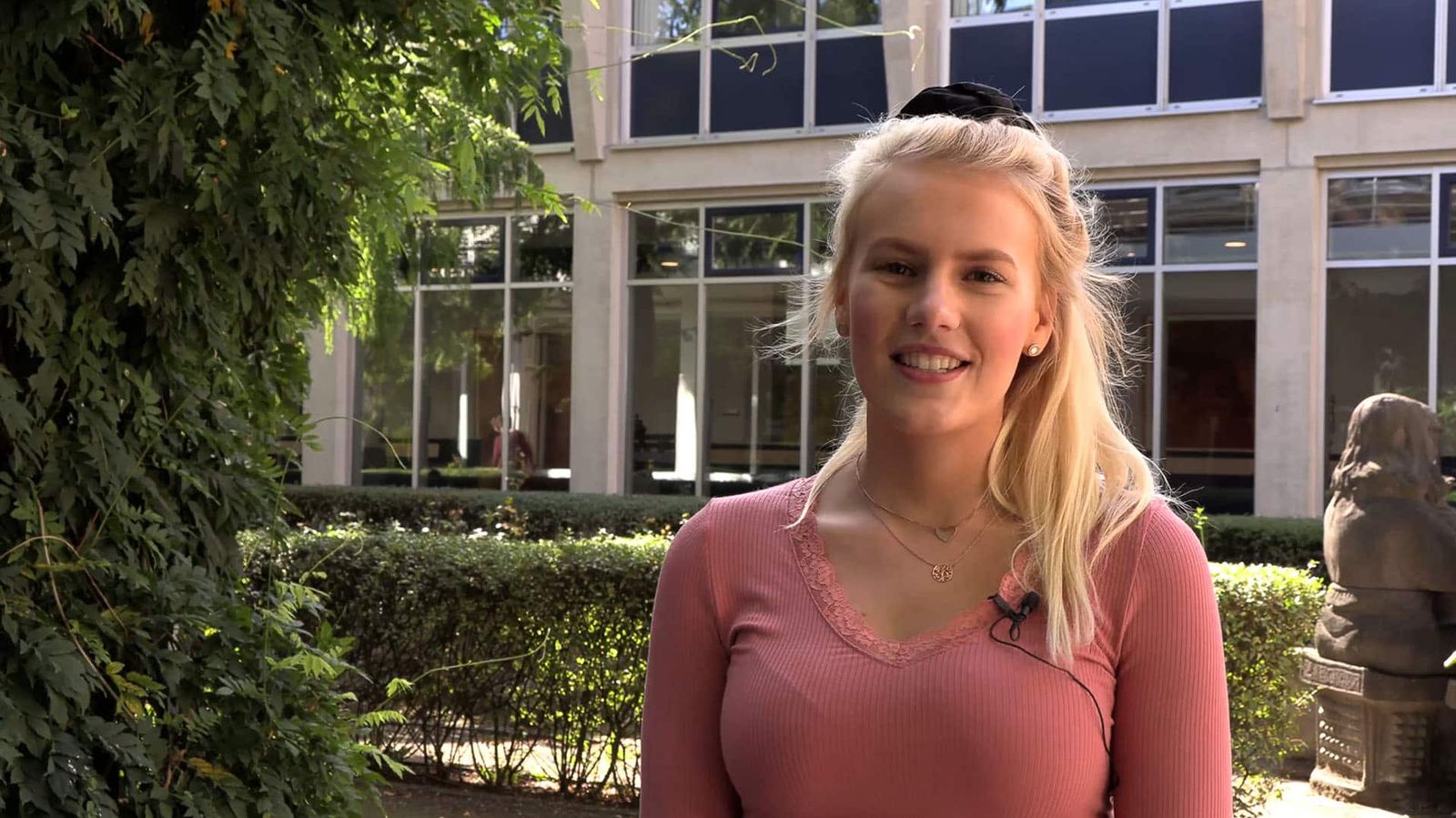 Eine junge Frau, die ehrenamtlich für den Malteser Hospizdienst arbeitet, steht draußen und schaut in die Kamera.