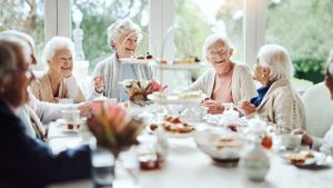 Eine Kaffeegesellschaft aus lächelnden älteren Frauen.