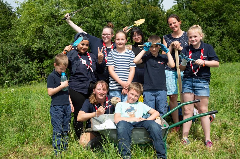 Nour posiert mit anderen Maltesern und Kindern im Garten vor der Kamera.