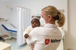 Eine Ärztin hält ein Baby auf dem Arm