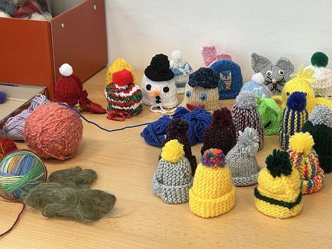 Ein Tisch voller Mini-Strickmützchen. (Foto: Malteser Speyer)